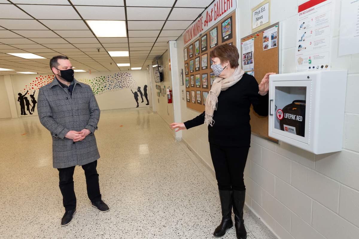 Derek Mombourquette, Minister of Education and Early Childhood Development, and Stephanie Campbell, principal of Malcolm Munroe Memorial Middle School in Sydney, with the school’s automated external defibrillator.