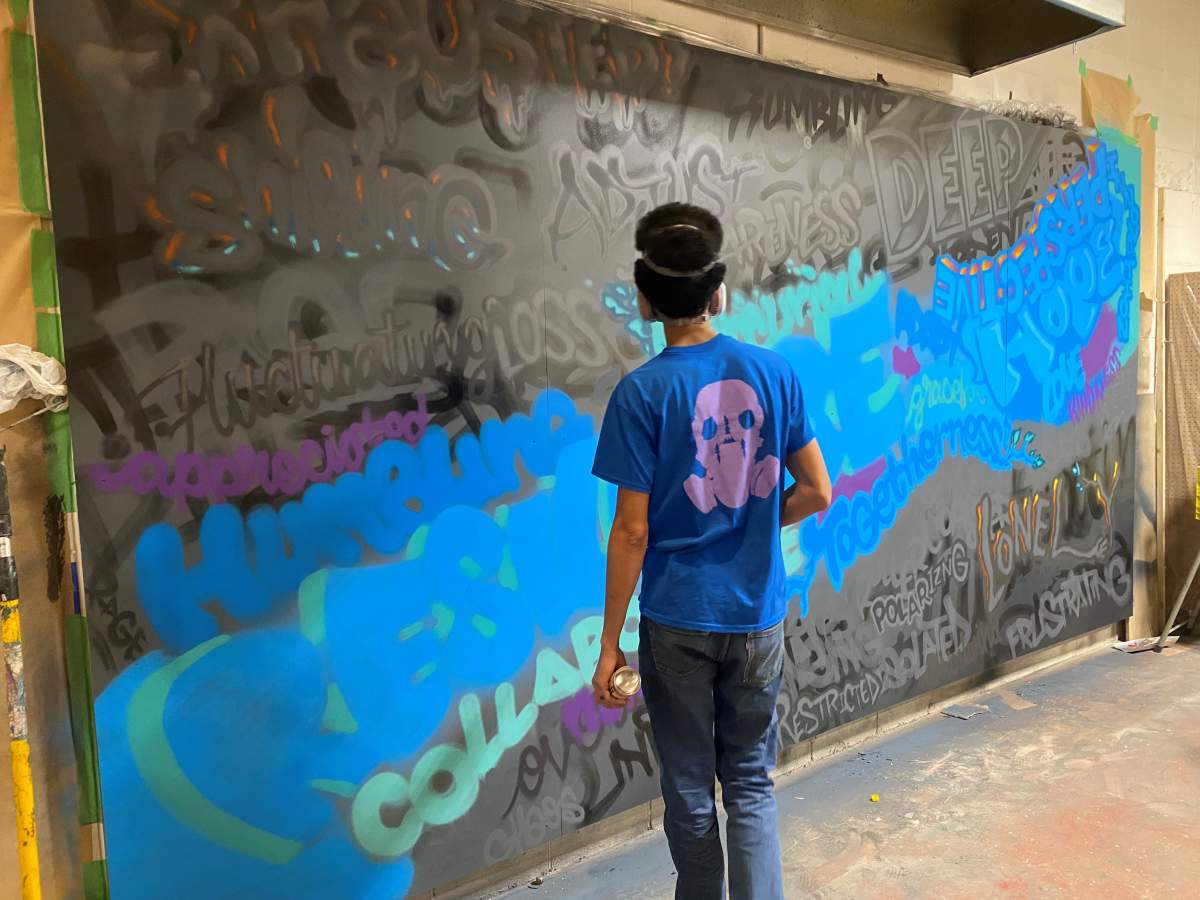 AJA Louden works on his mural on March 4, 2021