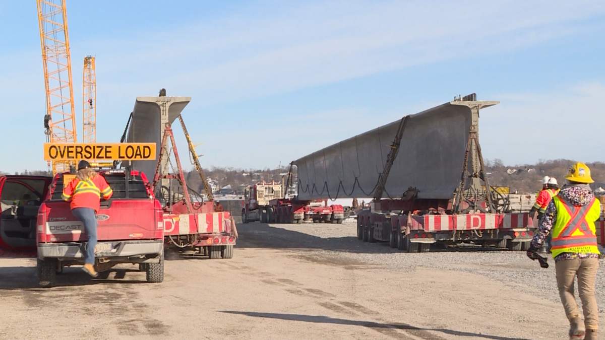 One of the 95 concrete girders to support the bridge deck arrives in Kingston. Each girder is 150 feet long and weighs over 180,000 pounds.