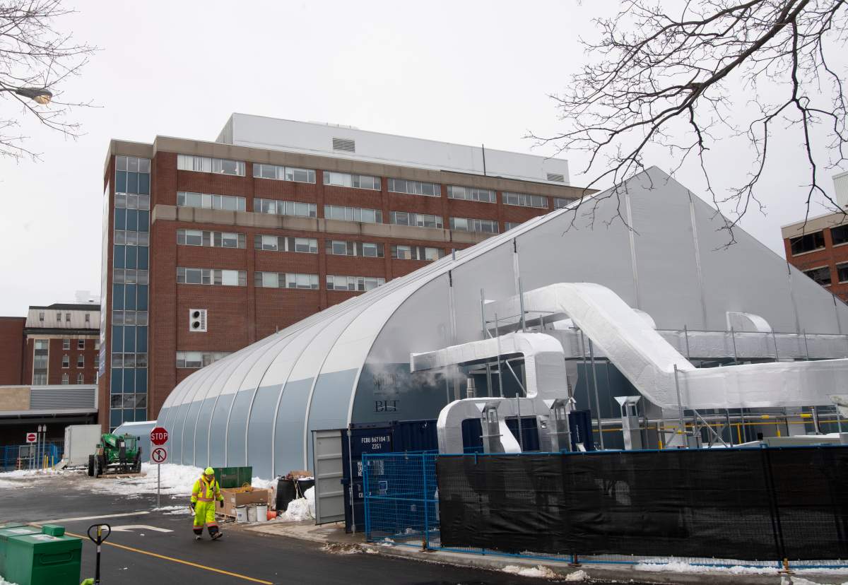 A worker walks past a temporary structure under construction outside the civic campus of the Ottawa Hospital Wednesday, January 6, 2021 in Ottawa. Ottawa Public Health says 95 per cent of acute card beds are currently occupied across the city's health-care system as of Tuesday, March 30, 2021.