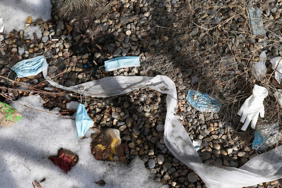 Discarded personal protective equipment, gloves and masks, used for protection against COVID-19, in a parking lot in Calgary, Alta., on Wednesday, March 3, 2021.
