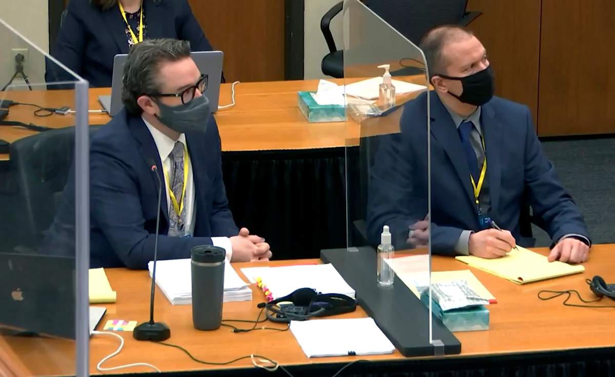In this image taken from video, defense attorney Eric Nelson, left, and defendant, former Minneapolis police officer Derek Chauvin, right, listen to Hennepin County Judge Peter Cahill during pretrial motions, prior to continuing jury selection in the trial of Chauvin, Thursday, March 11, 2021, at the Hennepin County Courthouse in Minneapolis, Minn.