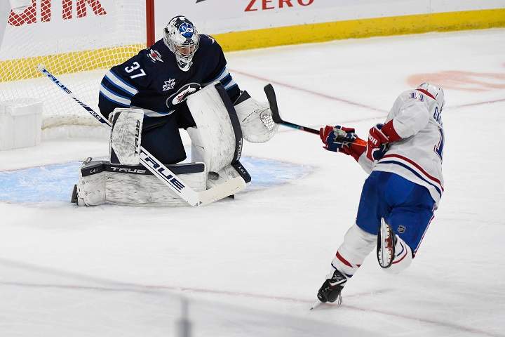 Winnipeg Jets goaltender Connor Hellebuyck (37) makes a save on a penalty shot by the Montreal Canadiens’ Brendan Gallagher (11) during second-period NHL hockey action in Winnipeg, Monday, March 15, 2021.