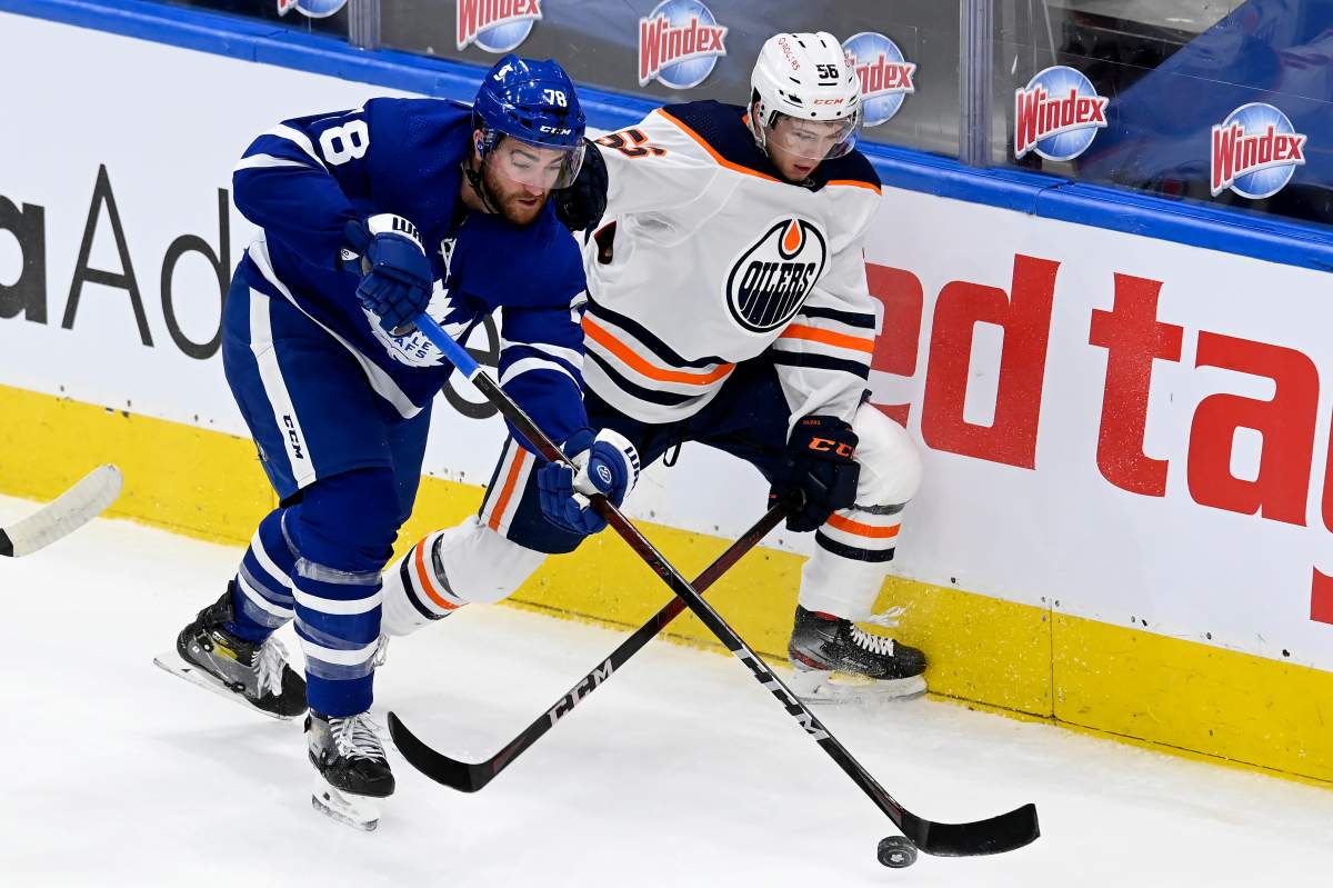 Toronto Maple Leafs defenceman T.J. Brodie (78) and Edmonton Oilers right wing Kailer Yamamoto (56) vie for control of the puck during first period NHL hockey action in Toronto, Saturday, March 27, 2021. THE CANADIAN PRESS/Frank Gunn.