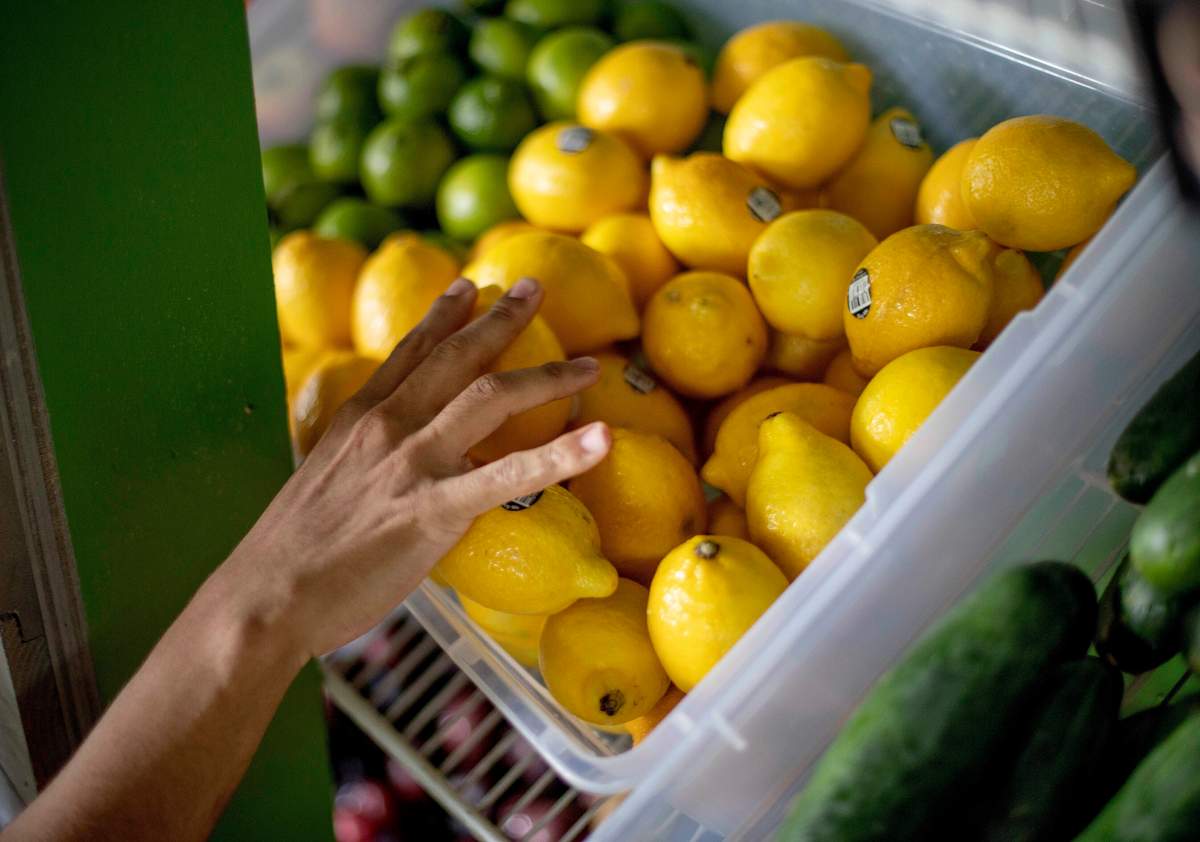 FILE - In this Aug. 21, 2019, file photo a worker stocks a produce stand at a metro station in Atlanta. Throwing away food is throwing away money. And with most wasted food winding up in landfills, it’s not great for the environment, either.