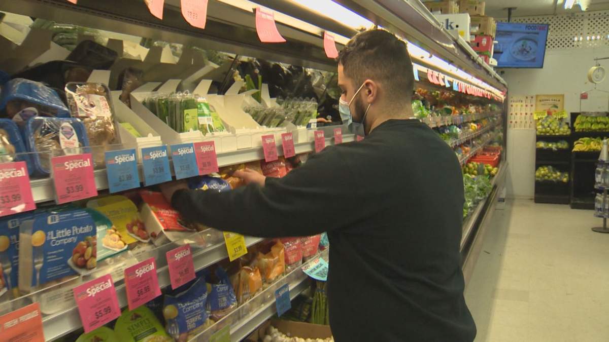 Tarik Zeid stocking produce shelves at Food Fare on Portage Avenue.