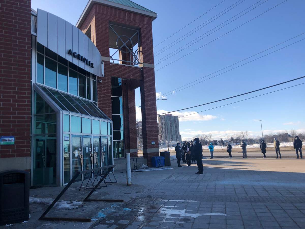 People line up outside of the COVID-19 vaccination clinic at the Agriplex in London, Ont., on March 4, 2021.