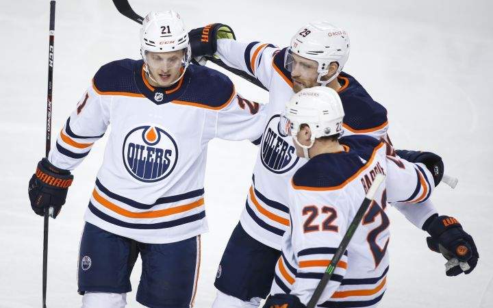 Edmonton Oilers’ Dominik Kahun, left, celebrates his goal with teammates Leon Draisaitl, centre, and Tyson Barrie during second period NHL hockey actionagainst the Calgary Flames in Calgary, Wednesday, March 17, 2021.