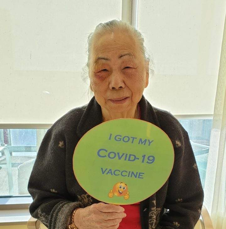 Chester Village resident holds up a sign after getting the COVID-19 vaccine