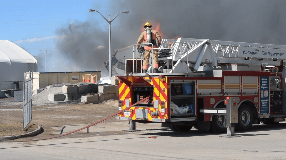 Firefighter witnesses the collapse of a building during at an industrial blaze in Burlington on March 12, 2021.