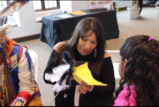 Rosa John, co-founder of Kehewin Native Dance Theatre, talks with a local youth at the Heard museum, during a youth mask workshop located in Phoenix, Ariz., in March 2020.