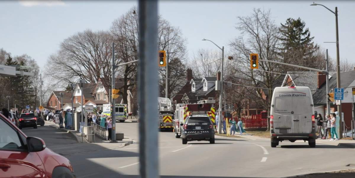 Emergency services vehicles parade past St. Mary's General Hospital.