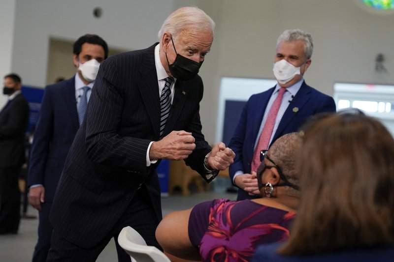 President Joe Biden talks to a person receiving a COVID-19 vaccination shot as he visits a vaccination site at Virginia Theological Seminary, Tuesday, April 6, 2021, in Alexandria, Va. 