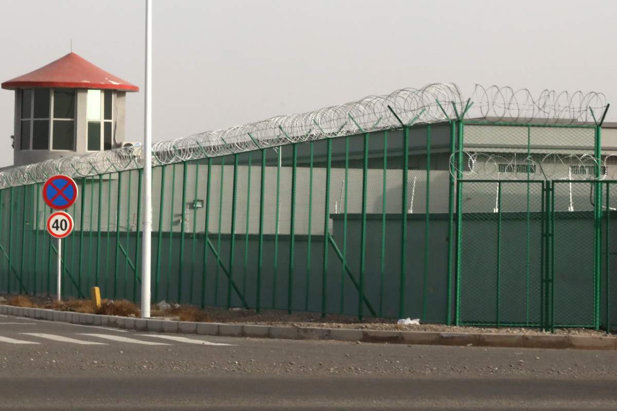 FILE - In this Monday, Dec. 3, 2018, file photo, a guard tower and barbed wire fence surround a detention facility in the Kunshan Industrial Park in Artux in western China's Xinjiang region.