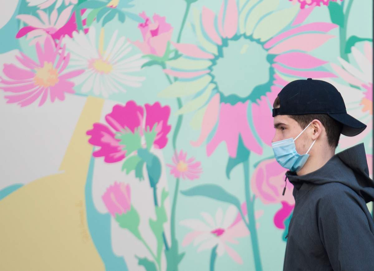 A man wears a face mask as he walks by a storefront in Montreal, Friday, April 2, 2021, as the COVID-19 pandemic continues in Canada and around the world. 