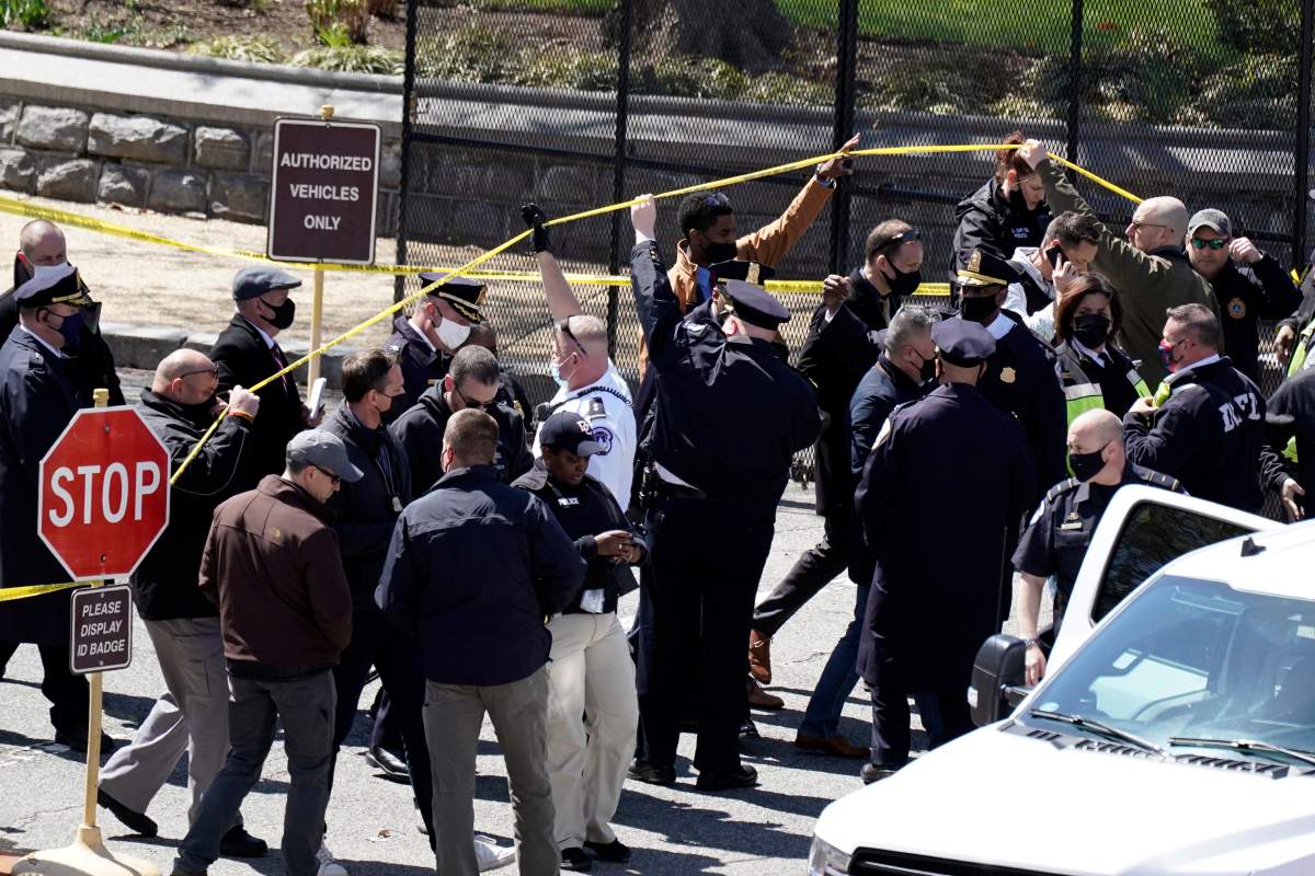 Police officers gather near a car that crashed into a barrier on Capitol Hill in Washington, Friday, April 2, 2021. (AP Photo/J. Scott Applewhite)