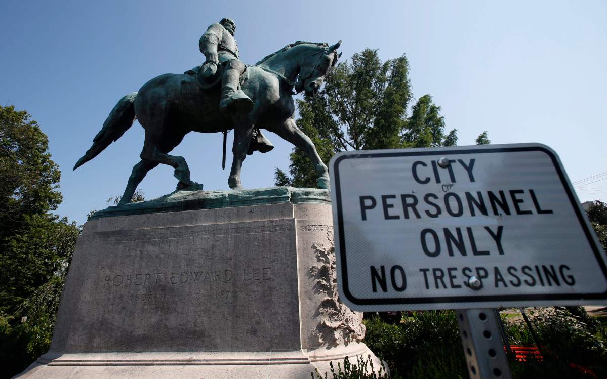 In this Monday, Aug. 6, 2018 photo, a No Trespassing sign is displayed in front of a statue of Robert E. Lee in Charlottesville, Va., at the park that was the focus of the Unite the Right rally.