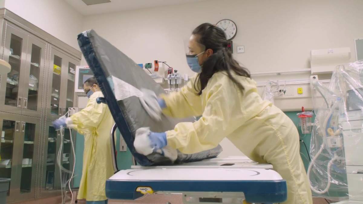 Felanie Aguila cleans a hospital bed at the University of Alberta hospital.