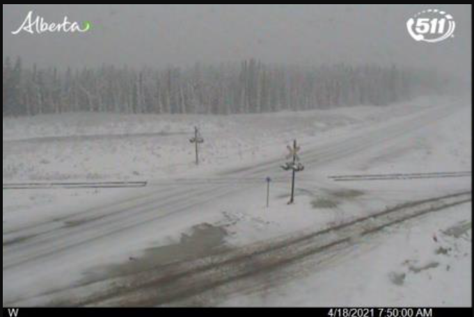 A camera on Highway 40 near Hinton Sunday morning shows snow-covered roads with limited visibility.