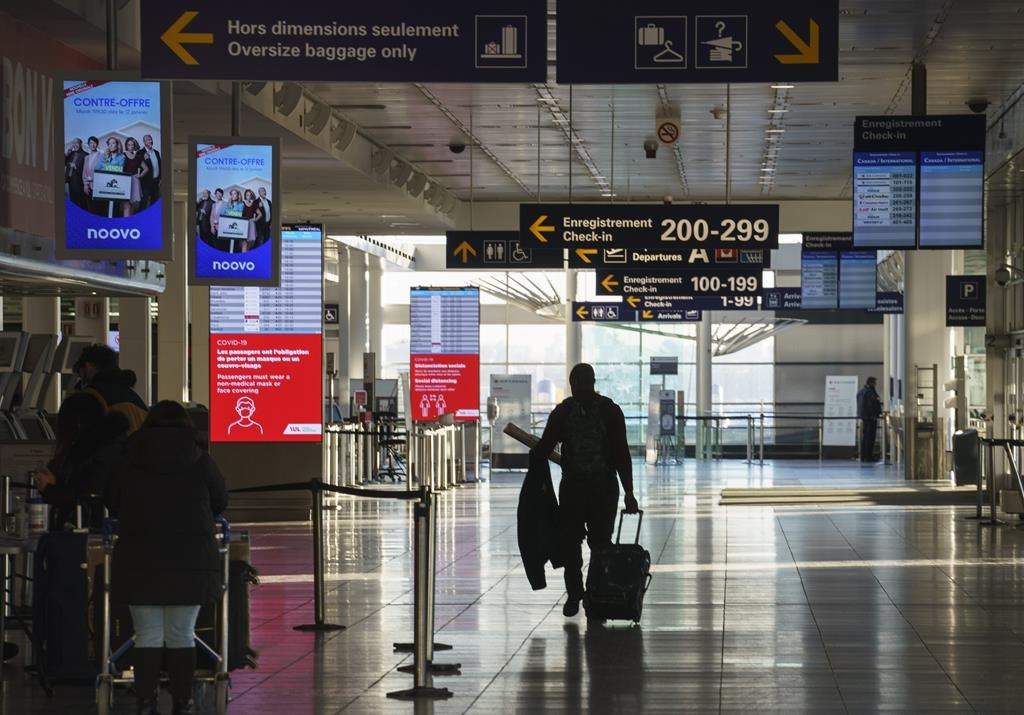 A passenger walks the halls at Montreal Trudeau Airport during the COVID-19 pandemic in Montreal, Wednesday, Dec. 23, 2020.