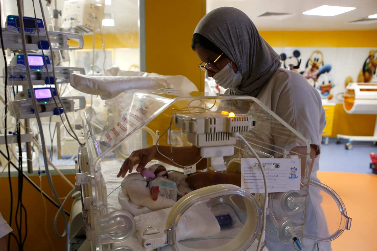 A Moroccan nurse takes care of one of the nine babies protected in an incubator at the maternity ward of the private clinic of Ain Borja in Casablanca, Morocco, Wednesday, May 5, 2021.