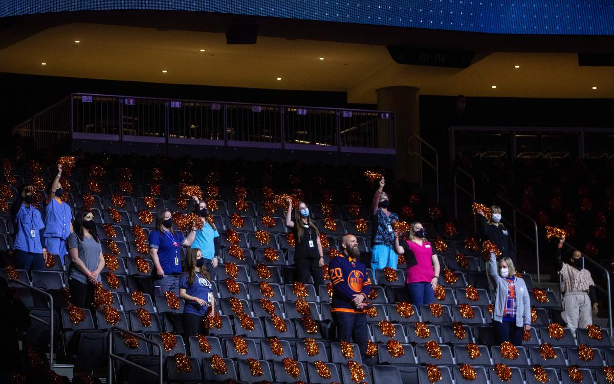 Frontline workers watch the game between the Edmonton Oilers and Winnipeg Jets during NHL playoff action in Edmonton on Wednesday, May 19, 2021.