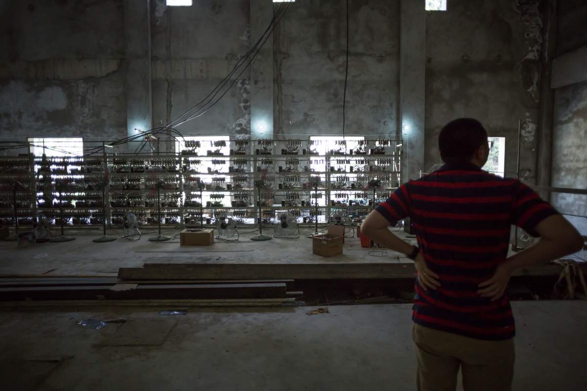 Ryan Xu, chief strategy officer and co-founder of Bitcoin Group Limited, shows off mining equipment inside his company’s bitcoin mine near Kongyuxiang, Sichuan, China.