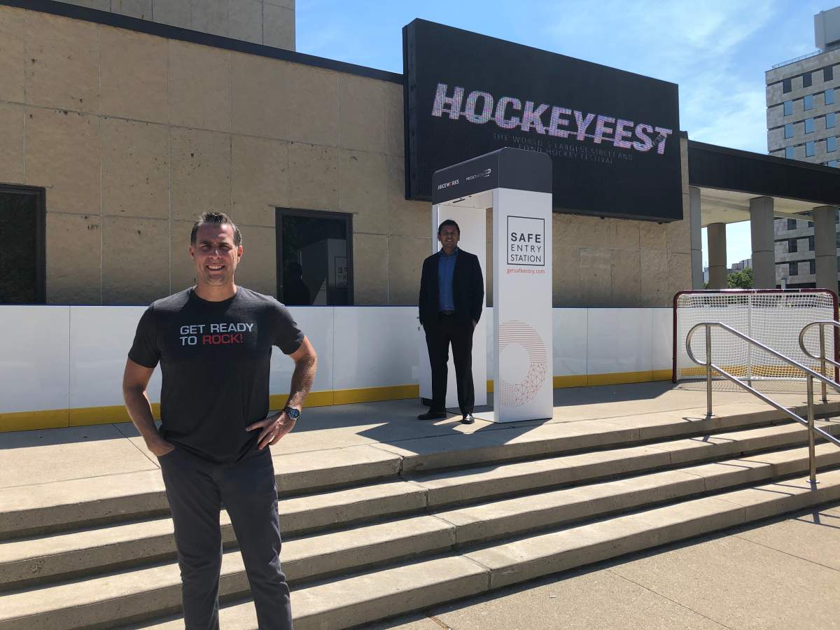 Jones Entertainment Group president Brad Jones (left) and PredictMedix COO Dr. Rahul Kushwah stand by a Safe Entry Station, a screening device that will be deployed at Hockeyfest and Rock the Park.