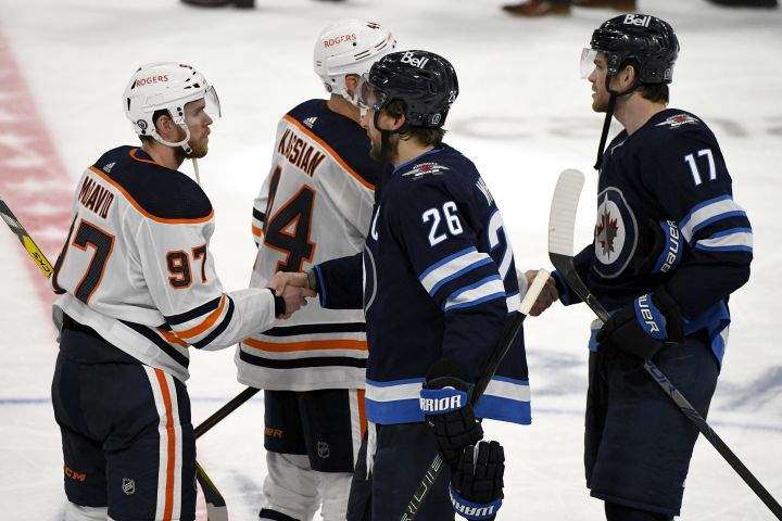 Winnipeg Jets’ Blake Wheeler (26) shakes hands with Edmonton Oilers’ Connor McDavid (97) after the Jets eliminated the Oilers following third overtime period NHL Stanley Cup playoff action in Winnipeg on Tuesday, May 25, 2021.