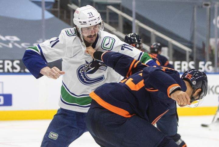 Edmonton Oilers’ Darnell Nurse (25) and Vancouver Canucks’ Zack MacEwen (71) fight during third period NHL action in Edmonton on Thursday, May 6, 2021.