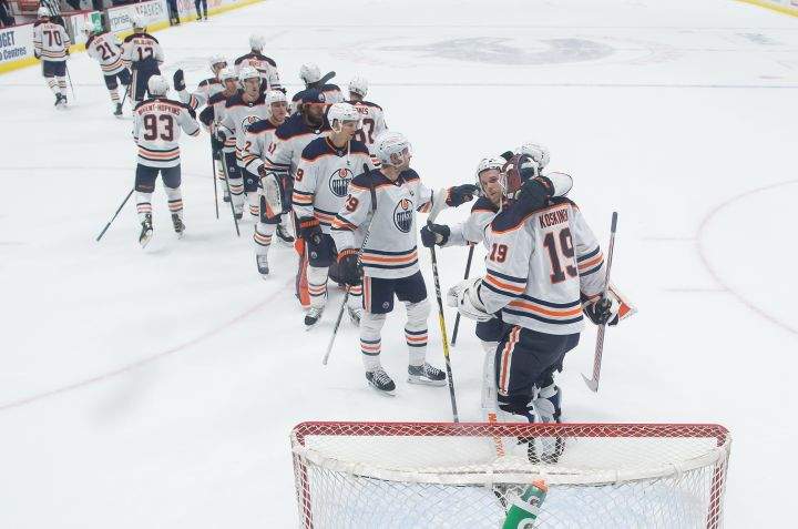 Edmonton Oilers goalie Mikko Koskinen (19), of Finland, and Connor McDavid (97) celebrate after Edmonton defeated the Vancouver Canucks 5-3 during an NHL hockey game in Vancouver, B.C., Monday, May 3, 2021.