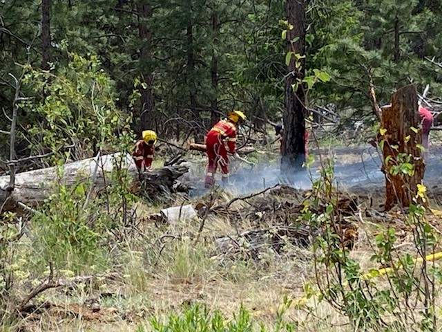 Crews douse a grass fire in Peachland on Thursday afternoon. The rank-one fire was estimated to be 15 metres (50 feet) by 30 metres (100 feet) in size, and was burning along a steep hill.