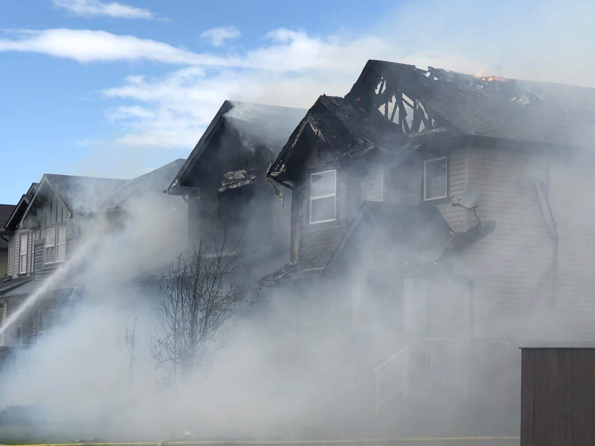 Smoke billows from a fire that force people from three homes in Calgary’s Skyview Ranch community on Tuesday.