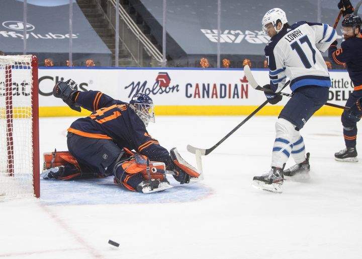 Edmonton Oilers goalie Mike Smith (41) makes the save on Winnipeg Jets’ Adam Lowry (17) during first period NHL Stanley Cup playoff action in Edmonton on Friday, May 21, 2021.