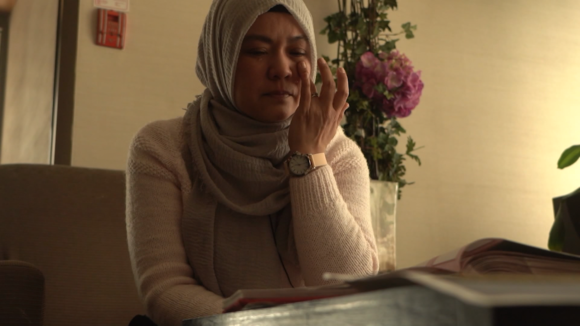 Kamila Telendibaeva breaks down while looking at photos of her husband, Huseyin Celil. The Chinese-Canadian has been detained in China since 2006.