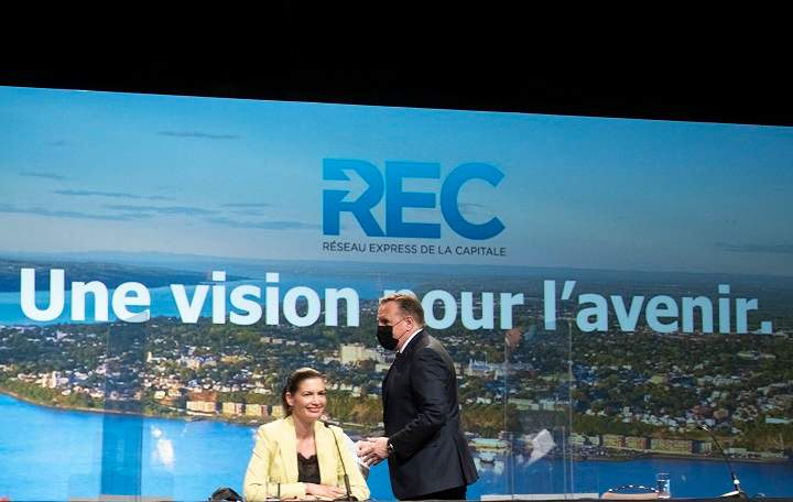 Quebec Premier François Legault walks to the podium to announce the new public transportation network, including a tramway and a tunnel to connect Lévis to Quebec City, Monday, May 17, 2021 in Quebec City. Quebec Deputy premier and Public Security Minister Geneviève Guilbault, sitting, is all smiles. 