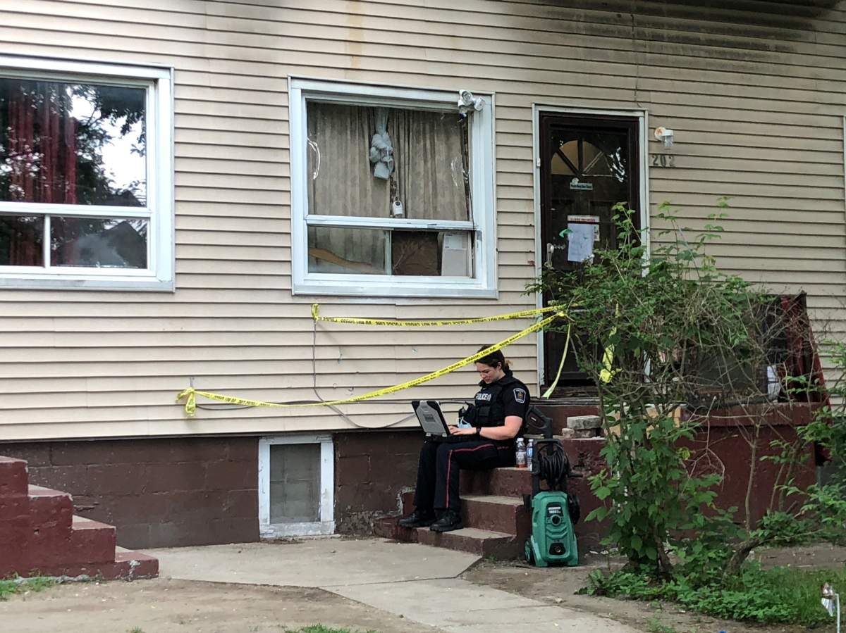 The front porch of a townhouse unit is taped off by police near Colborne and Simcoe streets, several blocks north from where officers say the body of a deceased male was located Wednesday morning, June 9, 2021. The death is being investigated as suspicious.