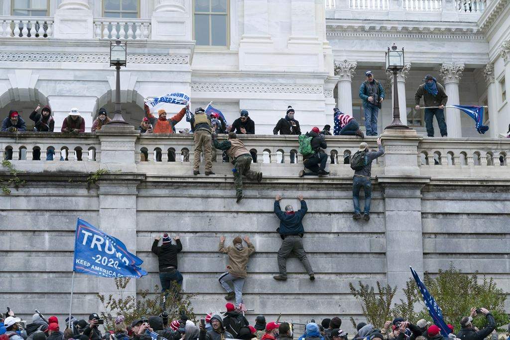 FILE - In this Jan. 6, 2021, file photo, supporters of President Donald Trump climb the west wall of the the U.S. Capitol in Washington, D.C.