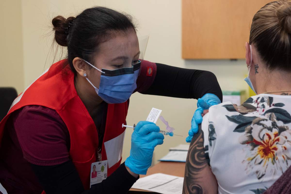 Nurse Venus Lucero administers the first Pfizer-BioNTech COVID-19 vaccine at the Ottawa Hospital to Jo-Anne Miner at a vaccination clinic, Tuesday, Dec. 15, 2020 in Ottawa.