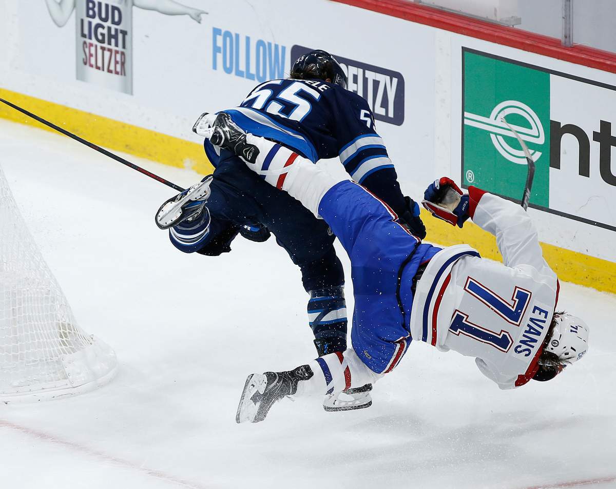Winnipeg Jets’ Mark Scheifele (55) hits Montreal Canadiens’ Jake Evans (71) after he scored an empty-net goal during third-period NHL Stanley Cup hockey action in Winnipeg, Wednesday, June 2, 2021.