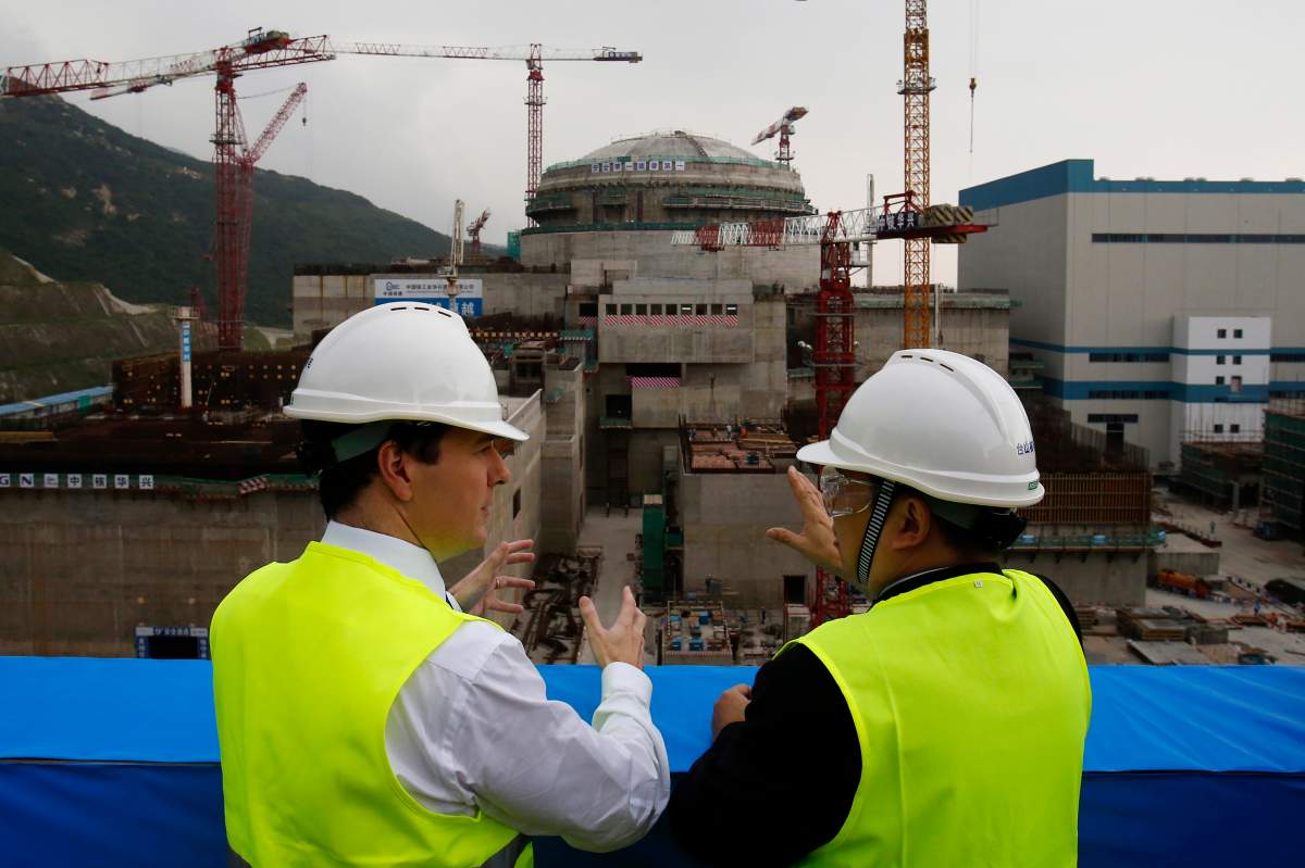 FILE - In this Oct. 17, 2013, file photo, then British Chancellor of the Exchequer George Osborne, left, chats with Taishan Nuclear Power Joint Venture Co. Ltd. General Manager Guo Liming as he inspects a nuclear reactor under construction at the nuclear power plant in Taishan, southeastern China's Guangdong province. The French joint operator of the Chinese nuclear plant near Hong Kong said Monday it is dealing with a “performance issue” but is currently operating within safety limits, following a report of a potential radioactive leak. (AP Photo/Bobby Yip, Pool, File).