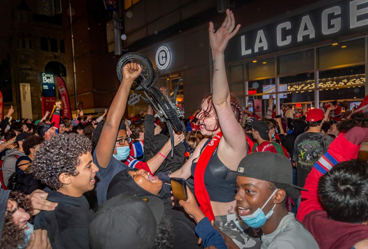 Montreal Canadiens fans celebrate their team's overtime victory over the Vegas Golden Knights in Game 3 of the NHL Stanley Cup semifinal outside of the Bell Centre in Montreal on Friday, June 18, 2021 in Montreal. 