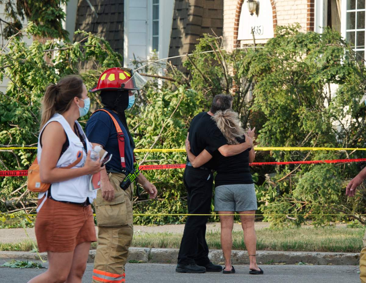 A couple console each other as they survey the damage after a tornado touched down in Mascouche, Que., northeast of Montreal, Monday, June 21, 2021. Dozens of homes were damaged and one death has been confirmed. THE CANADIAN PRESS/Ryan Remiorz