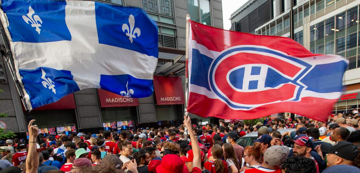 Flags of Quebec and the Montreal Canadiens fly in a crowd of several thousand as they watch the pre-game outside the Bell Centre in Montreal prior to game 6 NHL Stanley Cup playoff hockey semifinal action against the Vegas Golden Knights, in Montreal, Thursday, June 24, 2021.