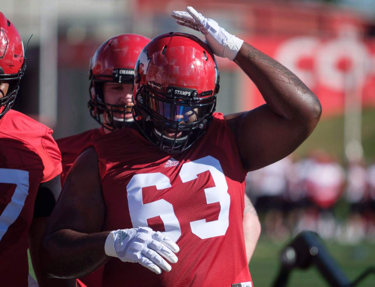 Calgary Stampeders' Derek Dennis adjusts his helmet on opening day of training camp in Calgary, Sunday, May 20, 2018.