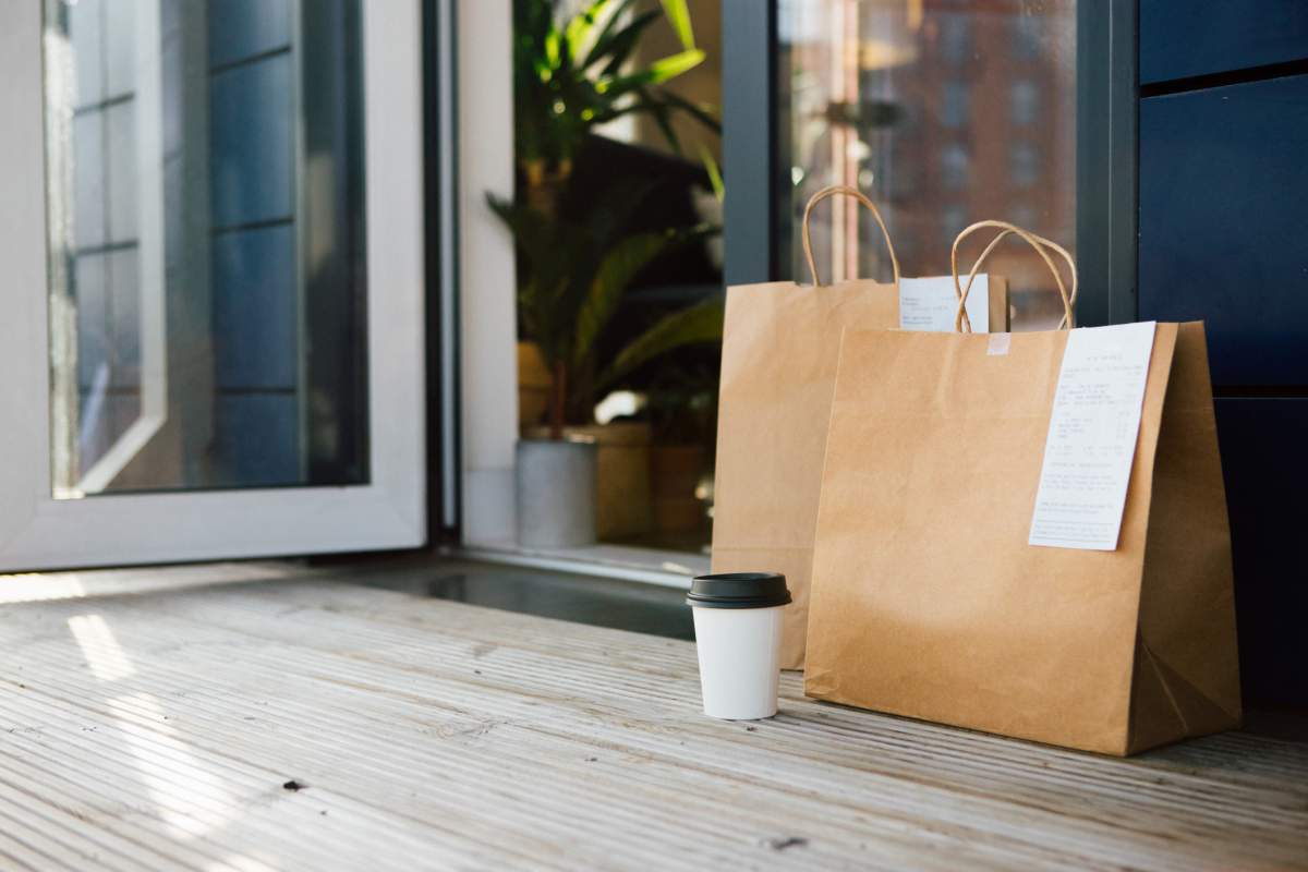 FILE - Takeaway meal packed in brown paper bag delivered to the front door of a residential building.
