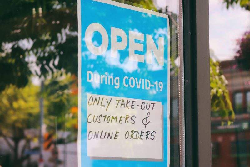 A sign indicates a restaurant is open during the COVID-19 pandemic but only for takeout or online orders.