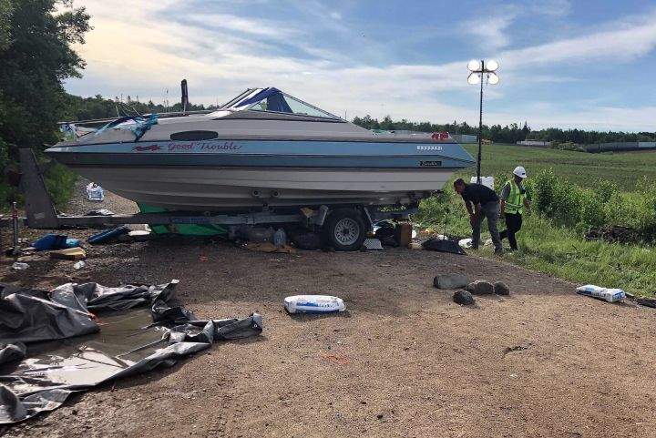 Security guards check on protesters under a boat blocking an entrance to an Enbridge Line 3 pumping station near Park Rapids, in northern Minnesota, Tuesday June 8, 2021.
