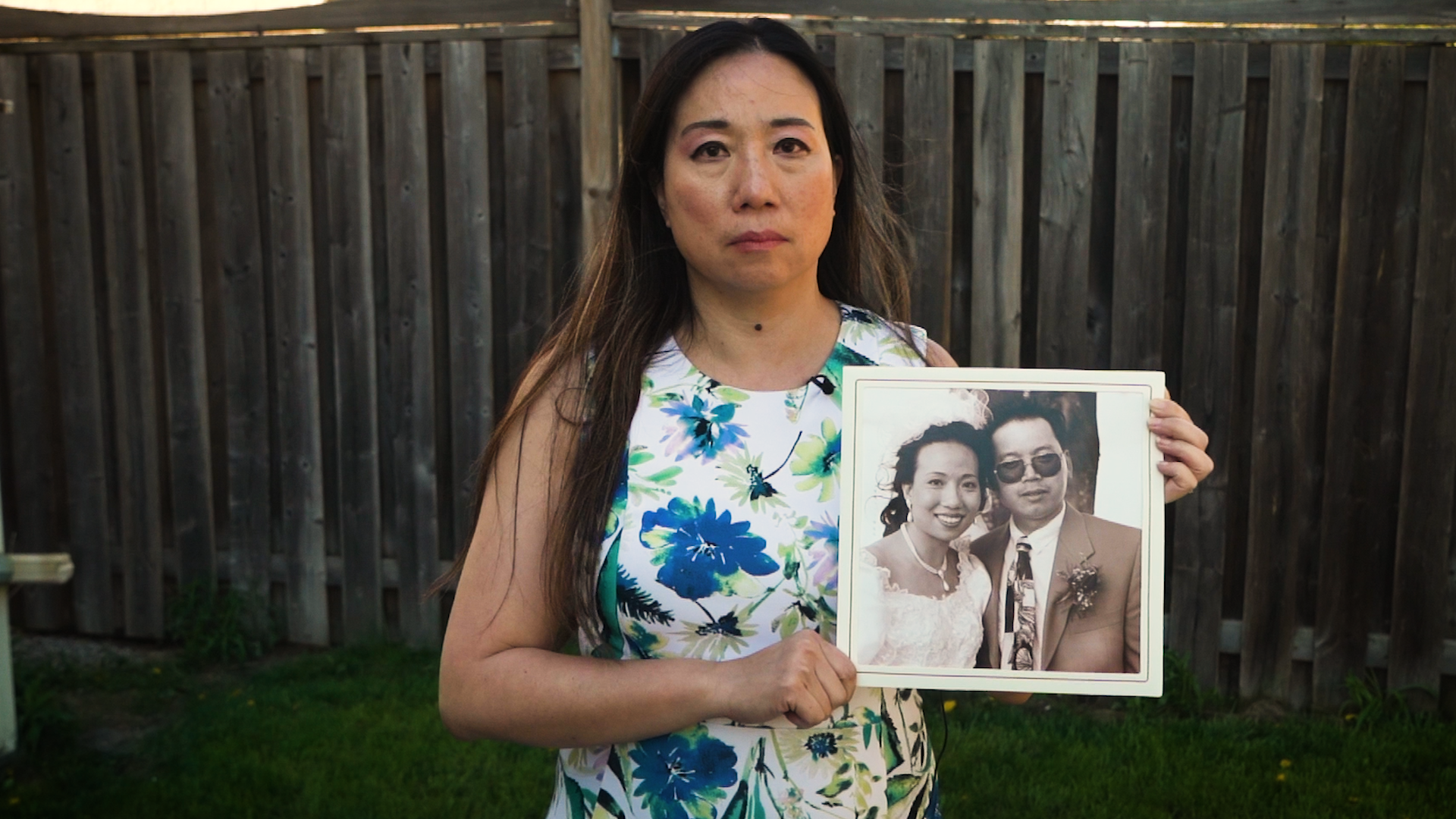Amanda Yeung Collucci holds a photo of her and brother, Godfrey Yeung, who died of COVID-19 he contracted at work in January.