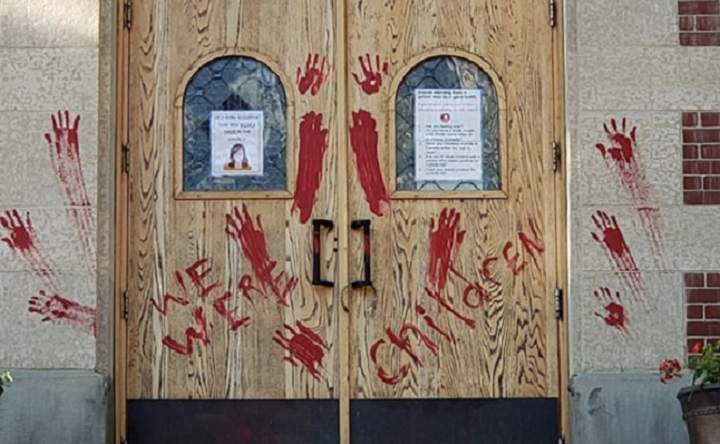 The doors of St. Paul Co-Cathedral in Saskatoon have been covered in paint following the discovery of hundreds of unmarked graves at a former residential school in Saskatchewan.
